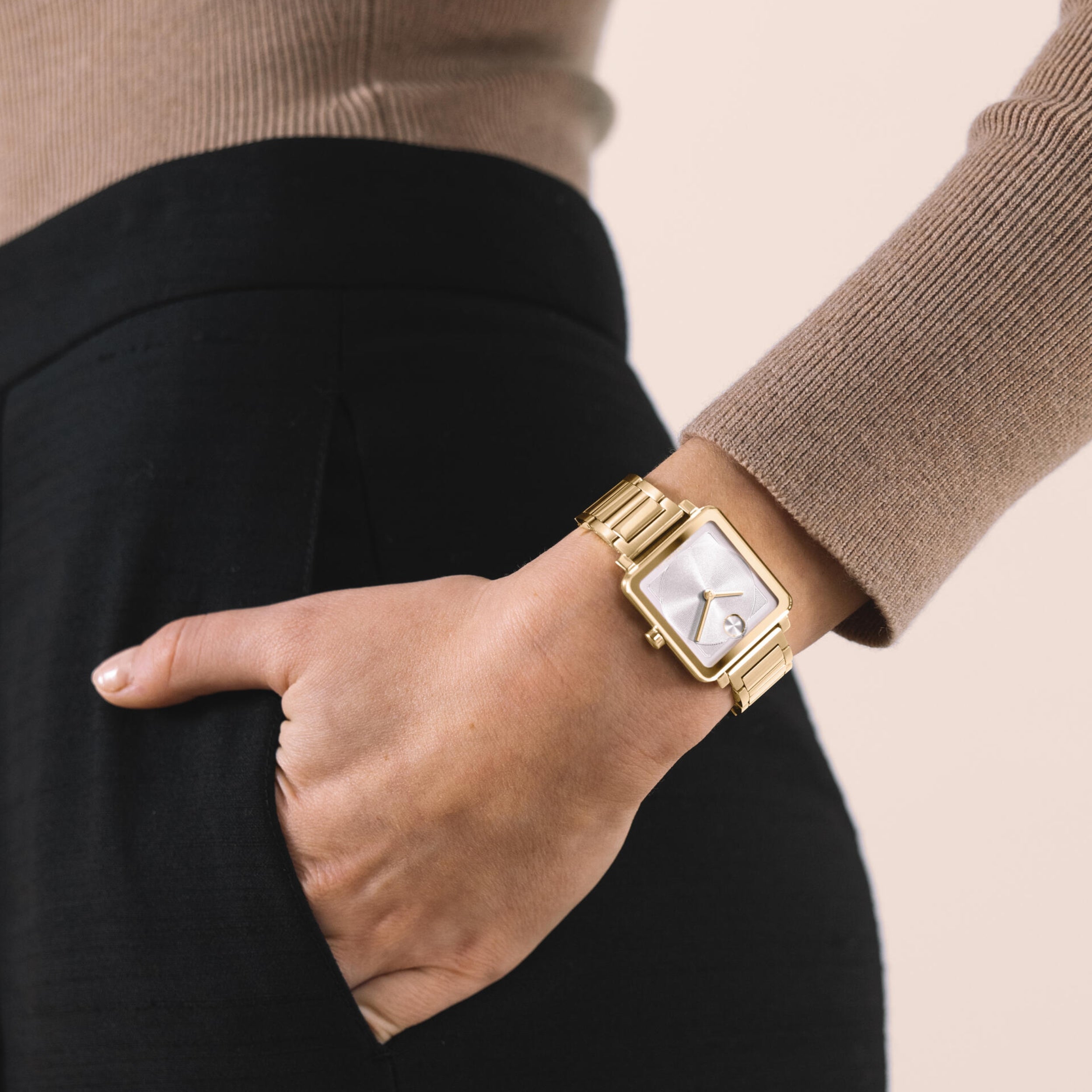 Movado Gold watch on a wrist with a neutral background