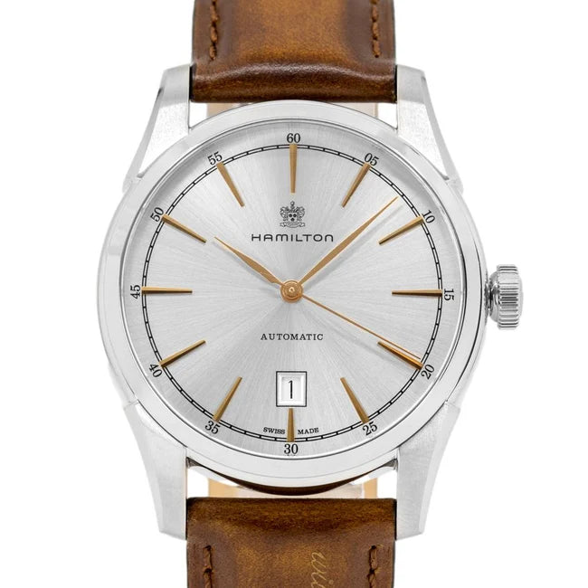 Hamilton automatic wristwatch with a silver sunburst dial, gold-tone hands and markers, and a brown leather strap on a white background.