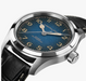 Hamilton Automatic watch with a textured blue dial, gold-tone numerals and hands, and a black leather strap, shown in a close-up studio shot.