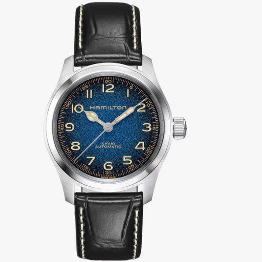 Hamilton Mann Automatic watch with a blue sunburst dial, silver-tone stainless steel case, and a black leather strap with white contrast stitching, shown on a light gray background.