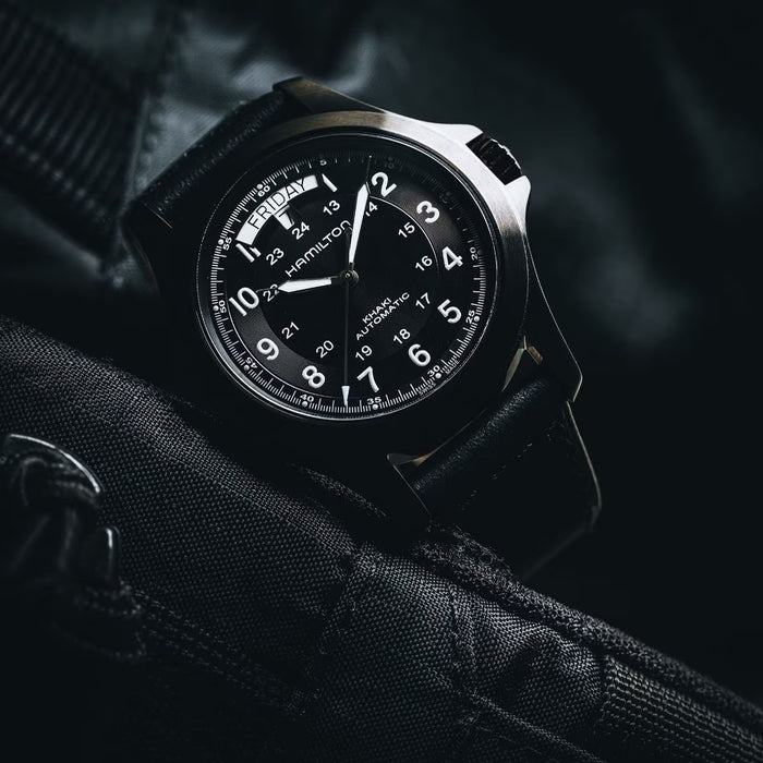 Black wristwatch with detailed face on a dark background