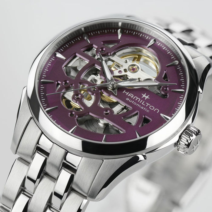 Hamilton watch with purple face and silver metal band on a light gray background