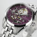 Hamilton watch with purple face and silver metal band on a light gray background