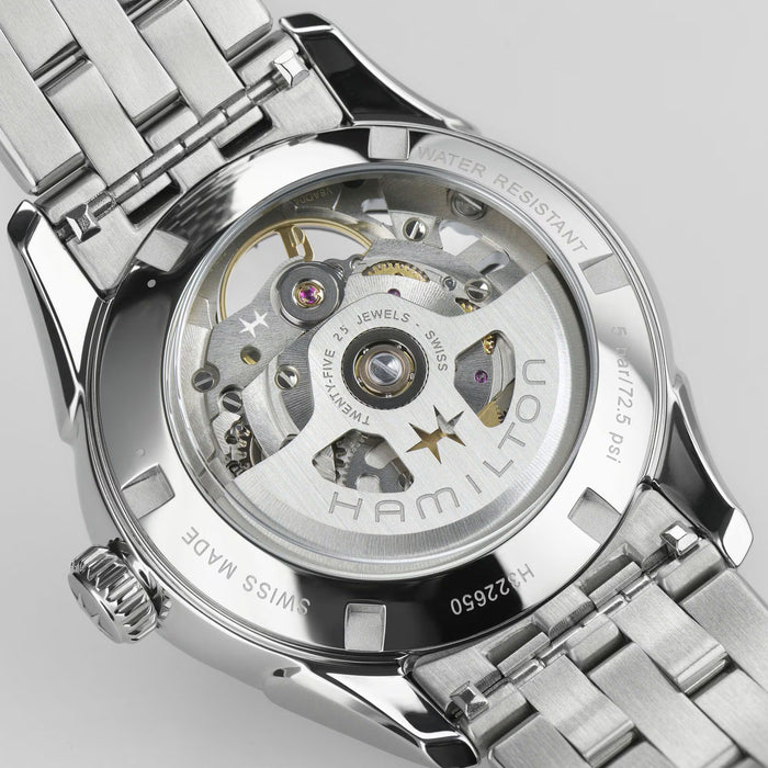 Close-up of a Hamilton watch with visible mechanical components on a light gray background