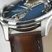 Close-up of a Hamilton watch with a brown leather strap and blue dial.