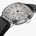 A close-up of a Hamilton watch with an octagonal silver dial, black leather strap, and a highly polished silver case featuring intricate hand-engraved details and bat-wing motifs.