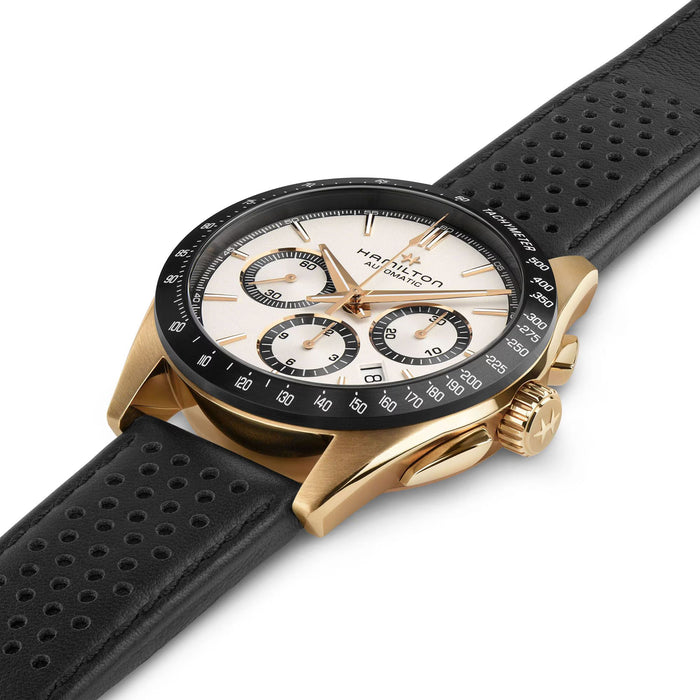 Hamilton watch with black perforated leather strap and gold case on white background