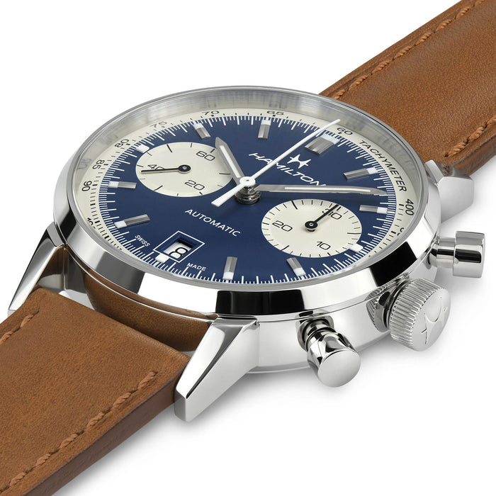 Watch with blue face and brown leather strap on a white background