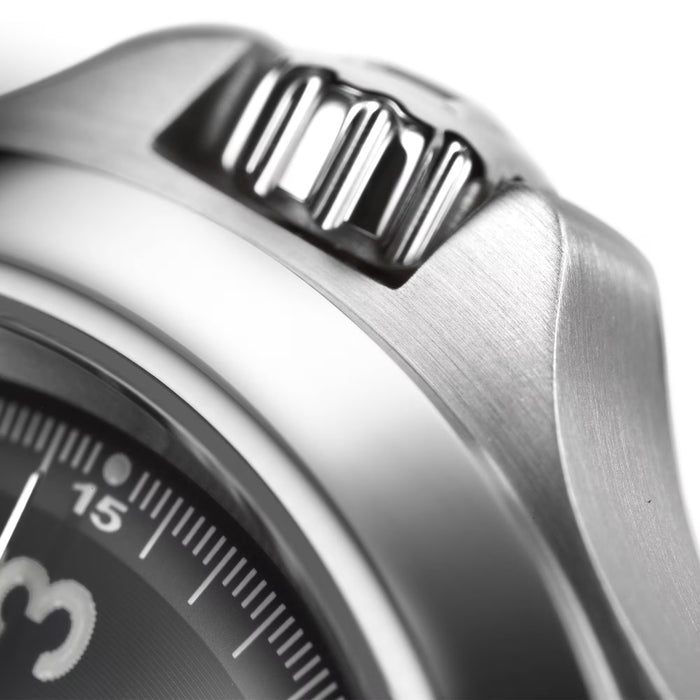 Close-up of a silver watch with a detailed texture on the case.