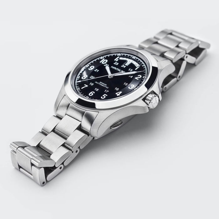 Silver watch with black dial on a light gray background