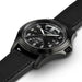 Black wristwatch with a detailed face on a white background