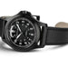 Black wristwatch with detailed face on a white background