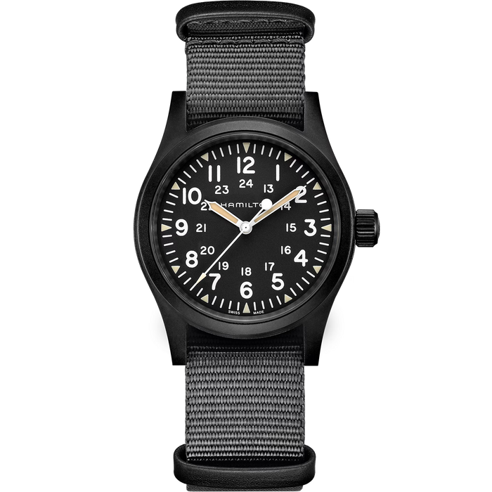 A black military-style analog watch with a black dial, white numerals, and a black woven fabric strap, shown against a plain white background.