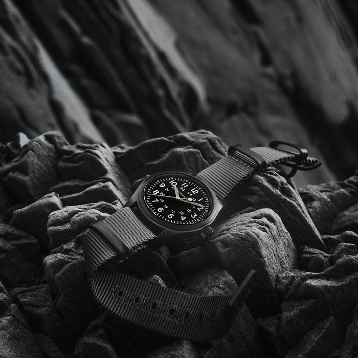 Black watch with a textured strap on a textured surface