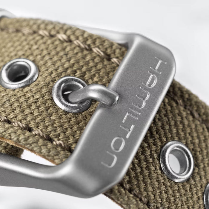 Close-up of a silver buckle on a brown leather strap with 'Hermes' branding.