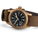 Watch with brown leather strap and bronze case on white background