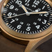 Close-up of a Hamilton watch with a black dial and gold casing.