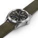 Watch with a green strap and black dial on a white background