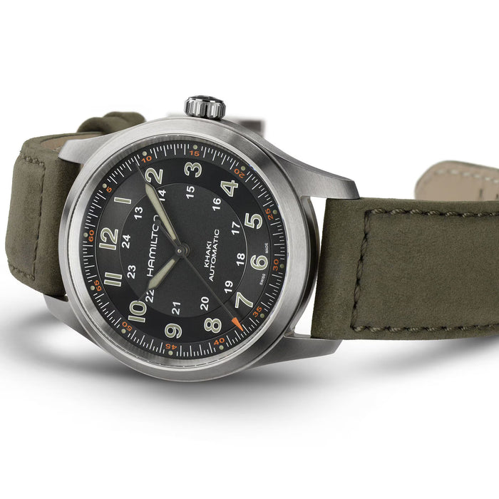 Wristwatch with olive green strap and black dial on a white background