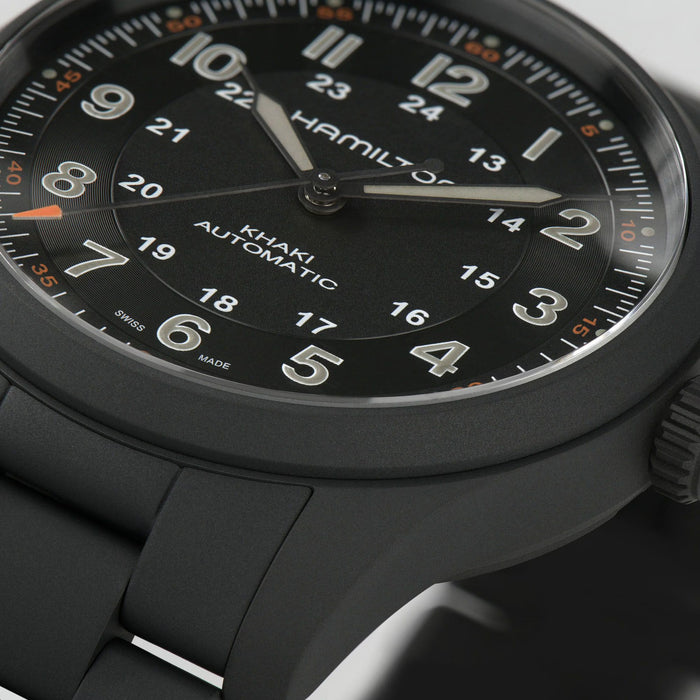 Hamilton watch with black dial and black strap on a light gray background