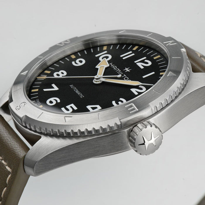 Hamilton watch with black dial and silver case on a light gray background