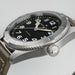 Hamilton watch with black dial and silver case on a light gray background