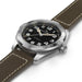 Watch with brown leather strap and black dial on a white background