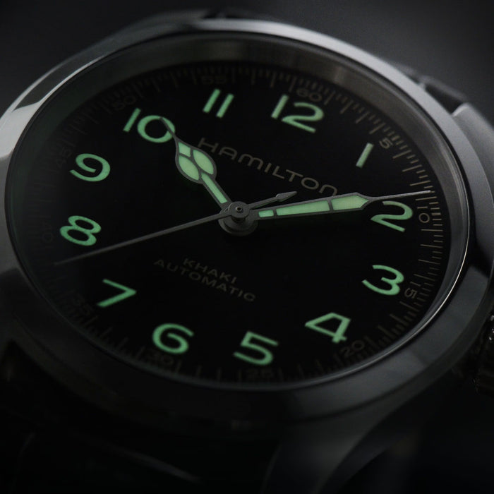 Hamilton watch with green glowing numbers on a dark background