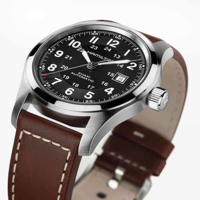 Hamilton watch with brown leather strap and black dial on a white background