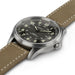 Watch with brown leather strap and black dial on a white background
