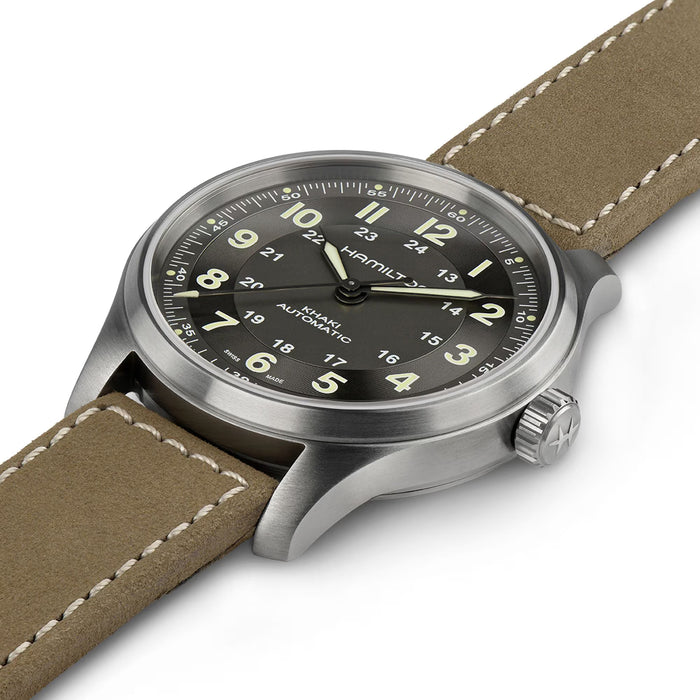 Watch with brown leather strap and black dial on a white background