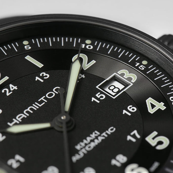 Close-up of a Hamilton watch face with black dial and white markings.