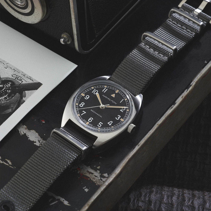 Wristwatch with black strap on a textured surface