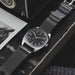 Wristwatch with black strap on a textured surface