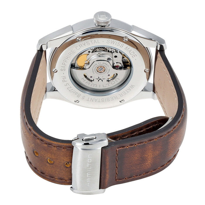 The back view of a Hamilton watch with a brown leather strap and a polished silver-tone case, showing the exposed mechanical movement through a sapphire crystal.