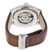 The back view of a Hamilton watch with a brown leather strap and a polished silver-tone case, showing the exposed mechanical movement through a sapphire crystal.